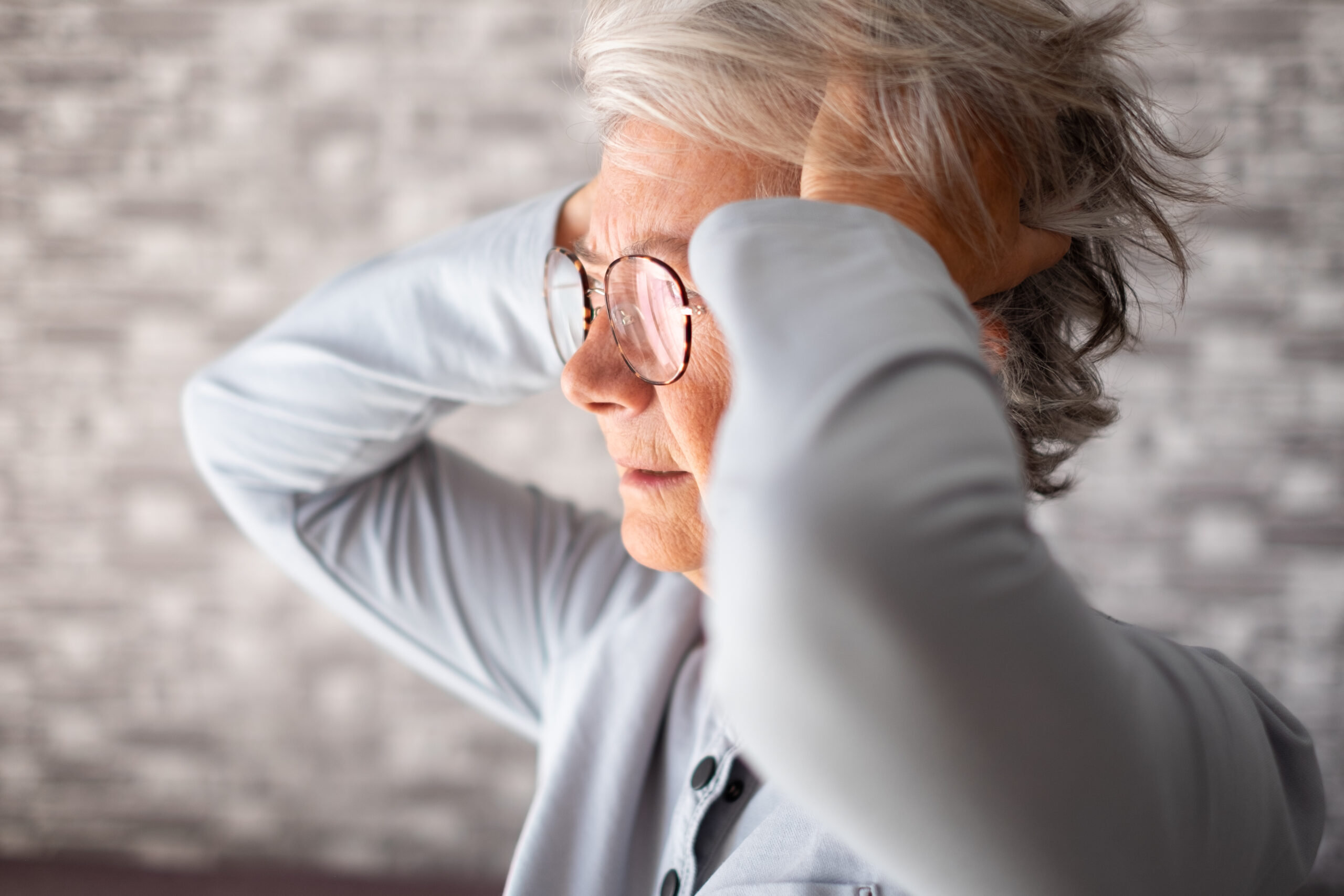 Frustrated unhappy old senior woman with hands in the hairs, eld
